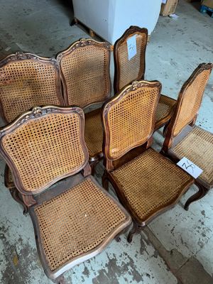 six chaises anciennes à dossier en rotin et assise en osier dans une pièce