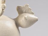 a white statue of a bird with wings on it ' s head