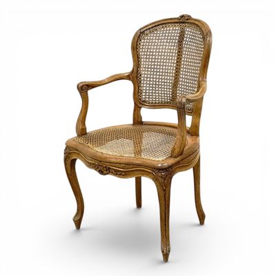 a wooden chair with a cane back and cane arms