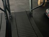 un tapis de course dans une salle de sport, à côté d'autres appareils