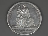 an old silver coin with a woman and child on it