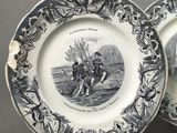 two plates with black and white designs on them sitting on a table