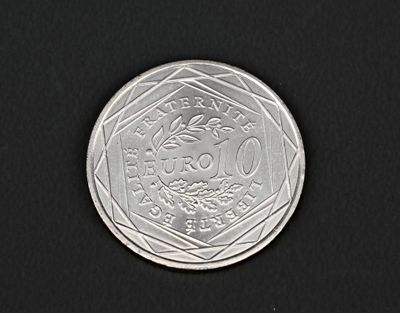 gros plan d'une pièce de monnaie en argent sur une surface noire