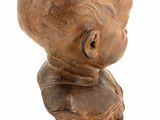 statue of a boy on a wooden base on a white background