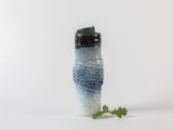 a close up of a water bottle with a plant in it