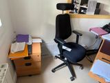a desk with a computer and a chair in the corner