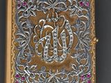 an ornate gold and silver box with a monogram on it