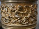a close up of a gold vase with a girl on it