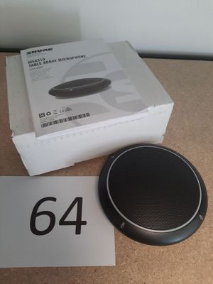 une enceinte noire posée sur une table, à côté d'une boîte