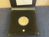 a gold coin in a black box on a blue carpet