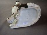 a figurine of a dog laying on a shell