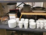 many cups and saucers on the shelves in the kitchen