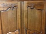 a wooden armoire with carvings on it in a room