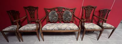 quatre chaises avec des coussins rembourrés à motifs floraux devant un mur rouge