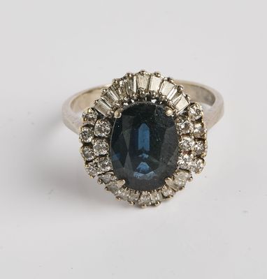 gros plan d'une bague avec une pierre bleue entourée de diamants blancs