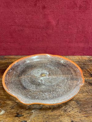 an orange and white bowl sitting on top of a wooden table