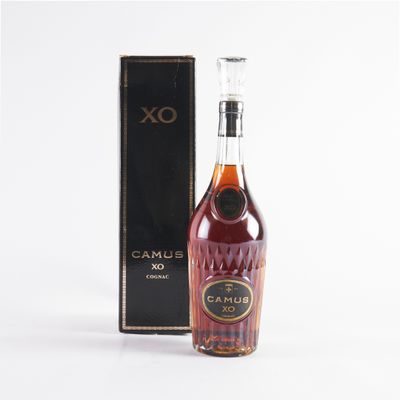 an old bottle of rum in front of a black box