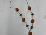 a necklace with orange beads and black beads on it