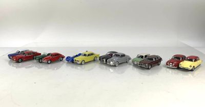 Six petites voitures sont alignées en rang sur une surface blanche.