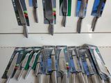 a lot of knives that are hanging on the wall