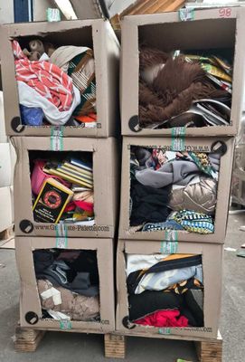 trois cartons remplis de vêtements, empilés les uns sur les autres