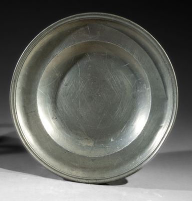 a silver plate sitting on a table with a black background