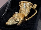 a gold cup shaped like a mouse in a black box