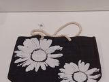 un sac à main noir et blanc orné de fleurs blanches