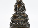 an image of a statue of a buddha sitting on a stool