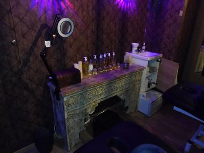 une table sur laquelle sont posées des bouteilles d'alcool, dans une pièce éclairée par des lumières violettes