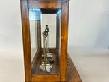 a small wooden clock with a glass case on it