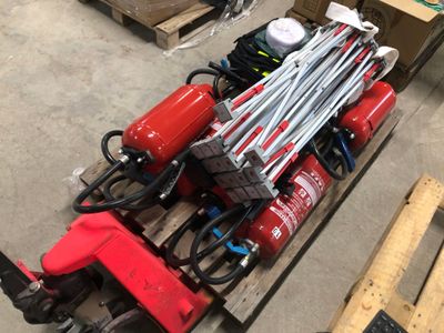 une borne d'incendie rouge posée sur une palette dans un entrepôt