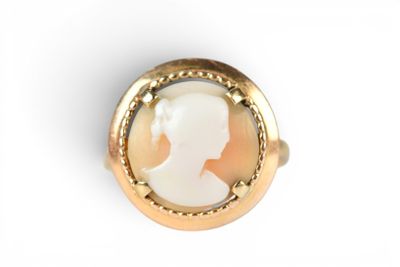 an image of a woman ' s profile in a gold plated ring
