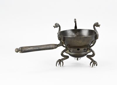 une petite casserole en métal munie d'une poignée et d'une cuillère posée dessus
