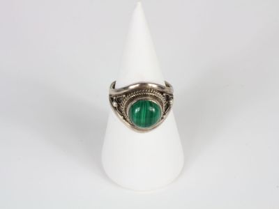 a close up of a ring with a green stone in it