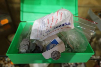 une boîte verte remplie d'objets divers, posée sur une table
