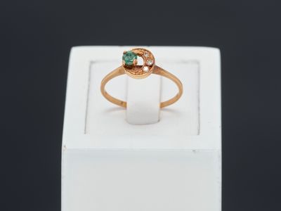 a close up of a gold ring with a green stone