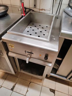 une cuisine équipée d'une cuisinière, d'un évier et d'autres appareils électroménagers
