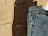 cinq paires de jeans étalées sur un lit