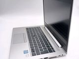 a silver laptop with a black keyboard on a white surface