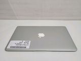 a silver apple laptop sitting on a white table