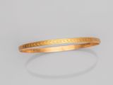un gros plan sur un bracelet en or orné d'un motif