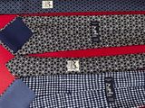 three ties are laid out on a red surface, one is blue and the other is white