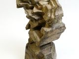 une sculpture en pierre posée sur une surface blanche