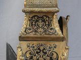 a gold and black clock sitting on top of a table
