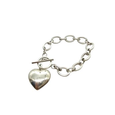 a close up of a silver bracelet with a heart on it
