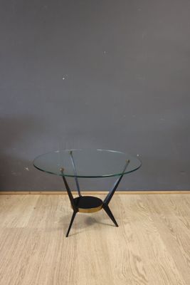 a glass coffee table with a black base and a wooden base