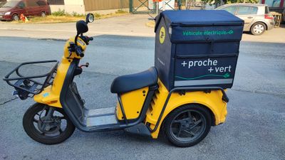 a yellow scooter with a box on the back of it