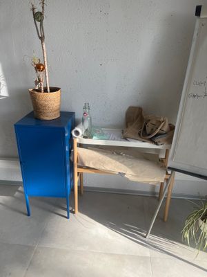une armoire bleue dans un coin d'une pièce, avec un tableau blanc accroché au mur