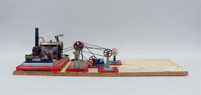 une petite maquette de machine à vapeur posée sur une planche en bois